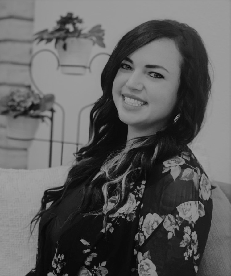 Shayla is a young woman with long dark hair, light skin, and is wearing a floral shirt in this black and white photo.