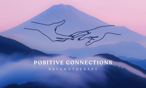 This logo shows a photo of mountains on a misty day. The closer, lower mountains are covered in clouds and the sky is pink. In the middle of an image is a line drawing of two hands reaching for each other with the fingertips touching. Below the hands are the words "Positive Connections Psychotherapy." The text is in all caps and white font with "Positive Connections" in bold and "Psychotherapy" below that in regular weight caps.